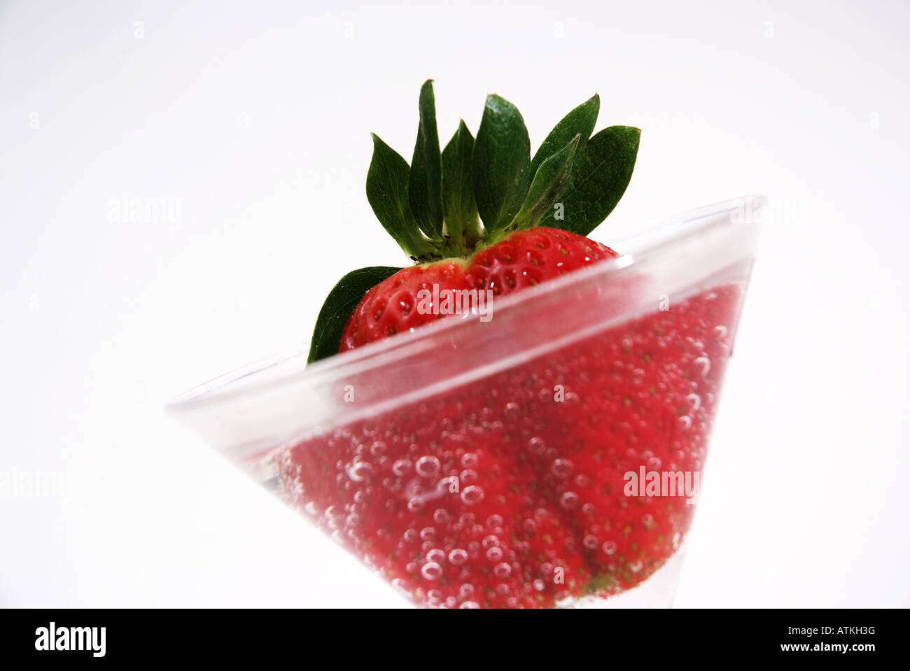 Fragola rossa in un bicchiere di acqua Rote Erdbeere in einem Glas mit Wasserblasen frisch Foto Stock