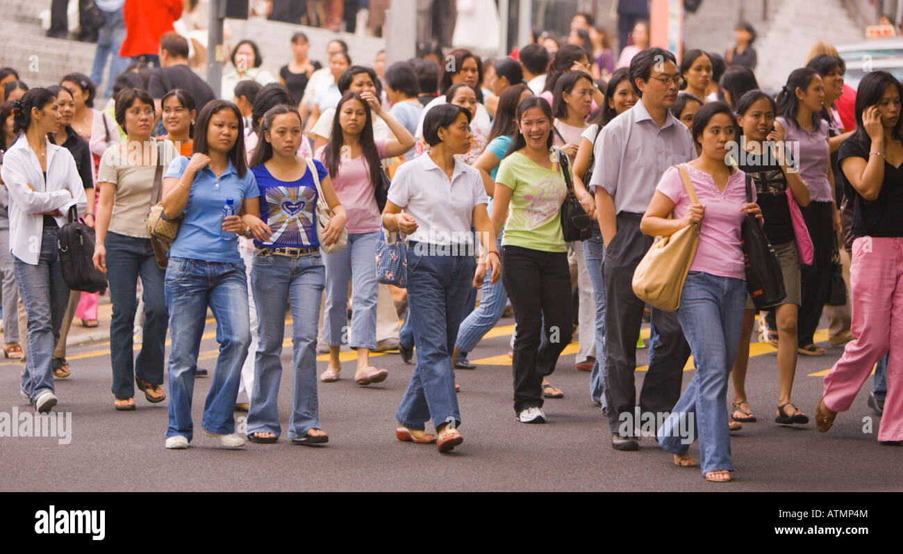 HONG KONG CINA lavoratori domestici Bambinaie dalle Filippine cross street dopo aver frequentato la messa Foto Stock
