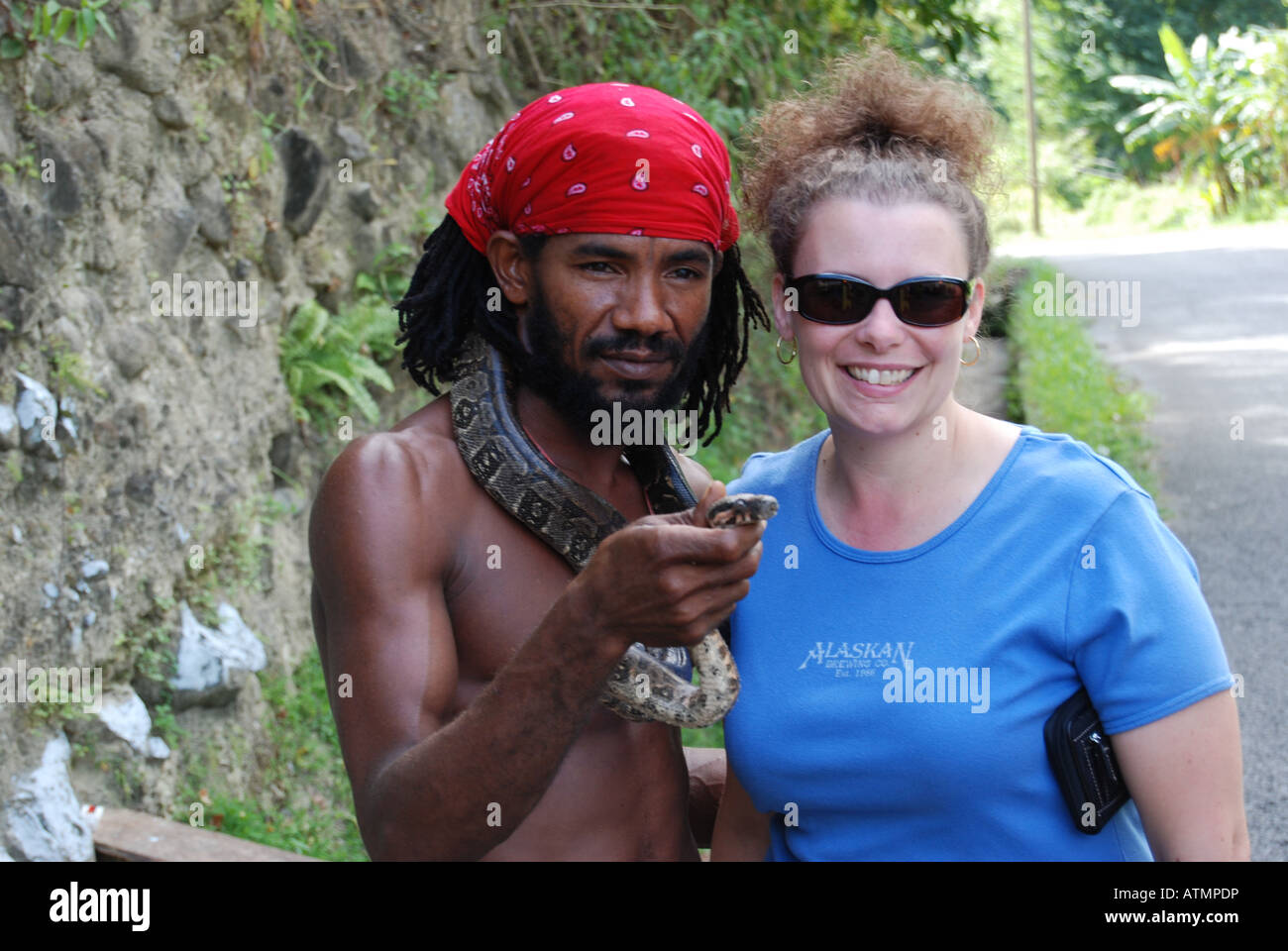 La donna in vacanza con un locale che mostra il suo un serpente, St Lucia, dei Caraibi Foto Stock