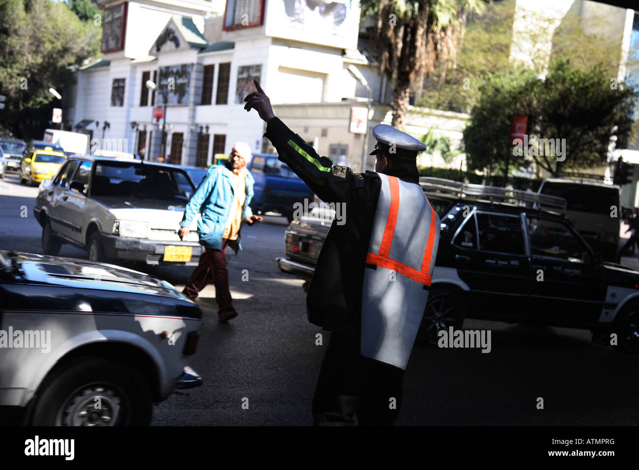Il traffico in Cairo, un vigile dirige il traffico con le sue mani e il fischio. Foto Stock