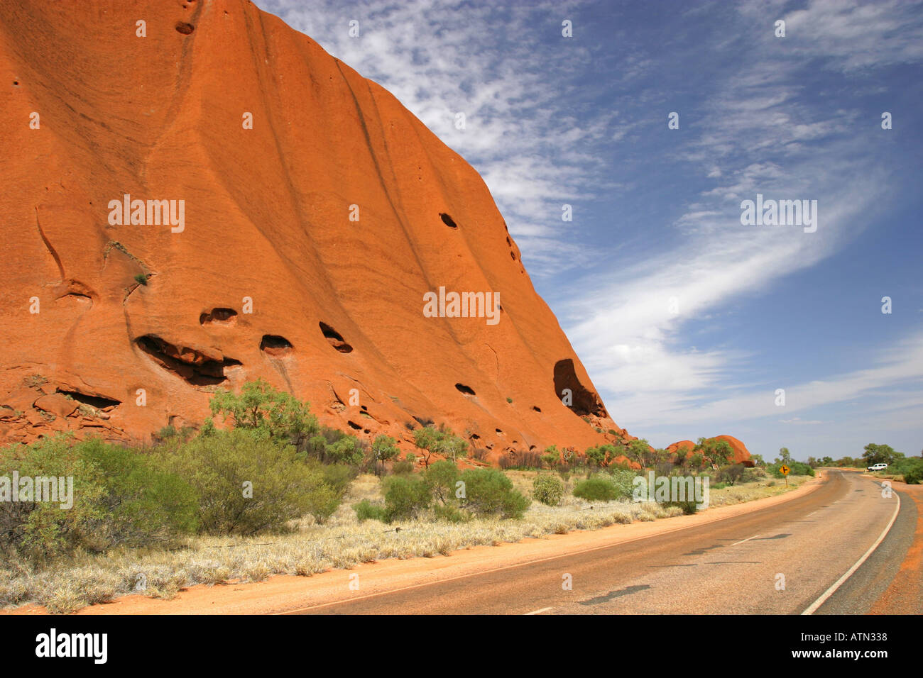 L'anello circolare strada si snoda intorno alla fine di Ayers Rock Uluru Red Centre Northern QL Australia Foto Stock