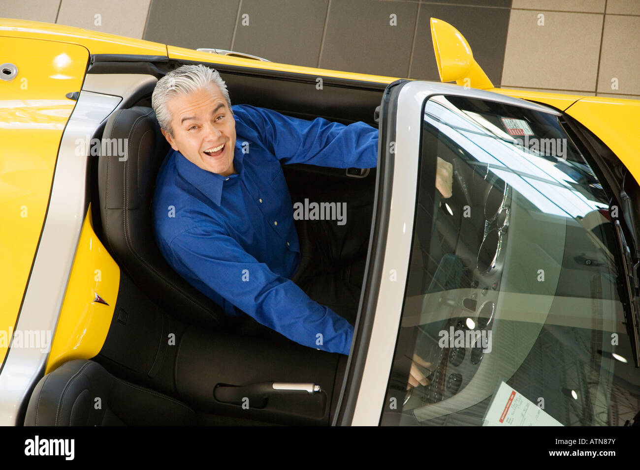 Ispanico venditore auto seduti in auto nuova Foto Stock