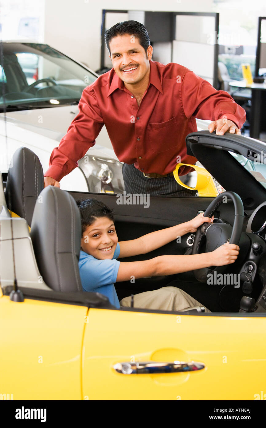 Ispanico padre e figlio guardando alla nuova vettura Foto Stock