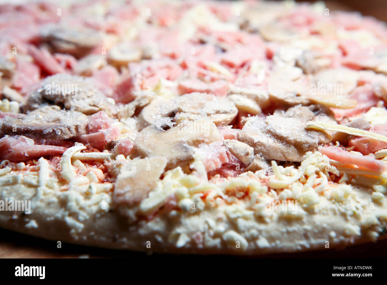 Primo piano di una pizza surgelata con funghi al formaggio e prosciutto  pronto per essere cucinato nel corvo Foto stock - Alamy