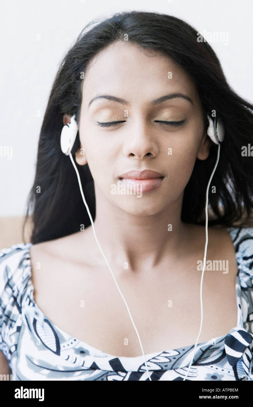 Close-up di una giovane donna che indossa gli auricolari Foto Stock