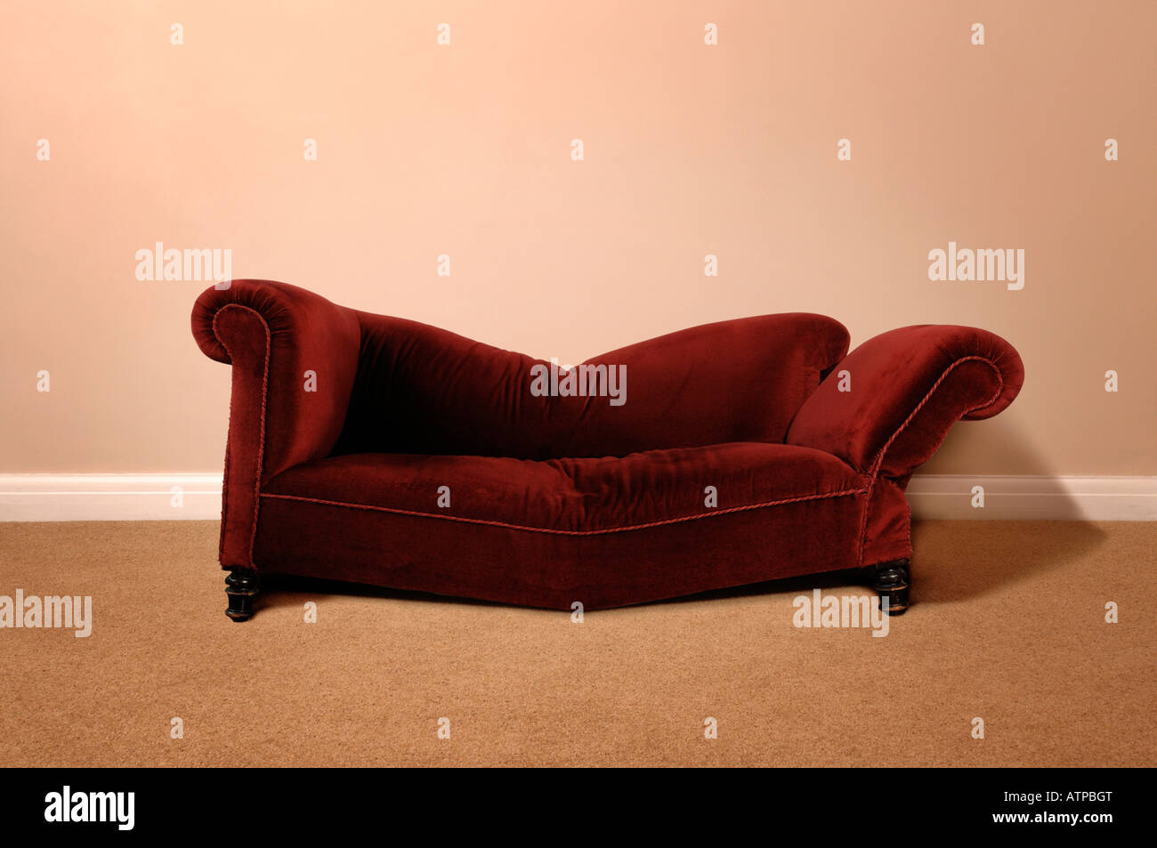 Rotture di divano rosso contro una parete Foto Stock