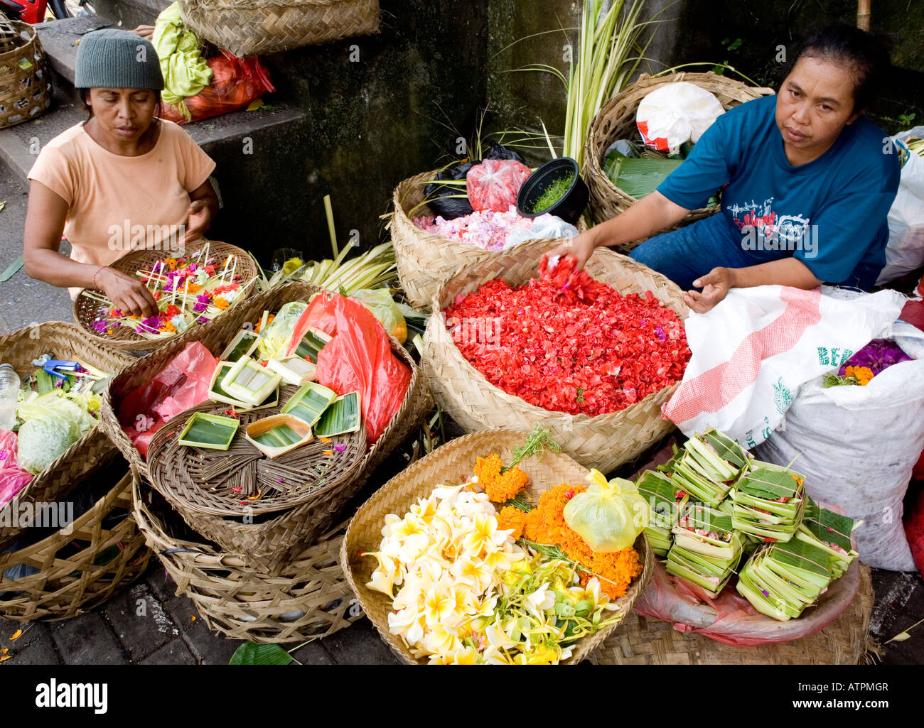 Donna locale rendendo le offerte di Temple Street Market Ubud Bali Indonesia Foto Stock