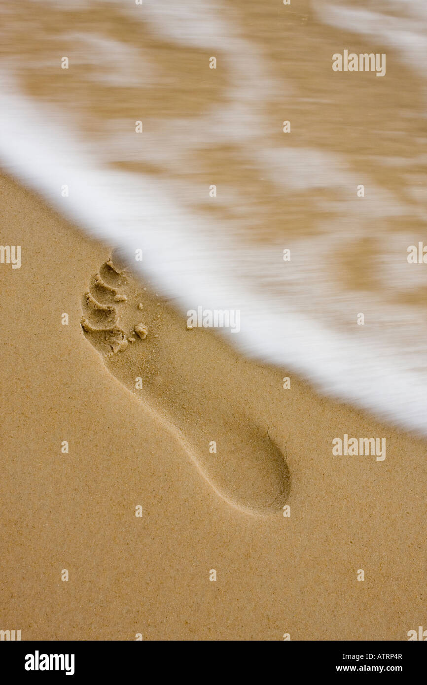 Impronta sulla spiaggia con un piccolo movimento onda sfocata Foto Stock