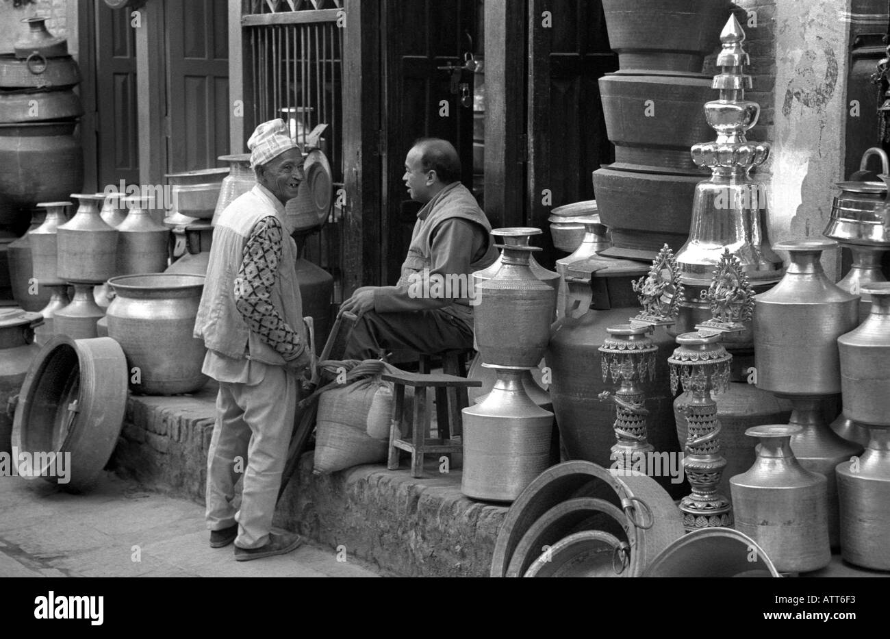 Due uomini in chat in strada fuori pot shop Patan Nepal Foto Stock