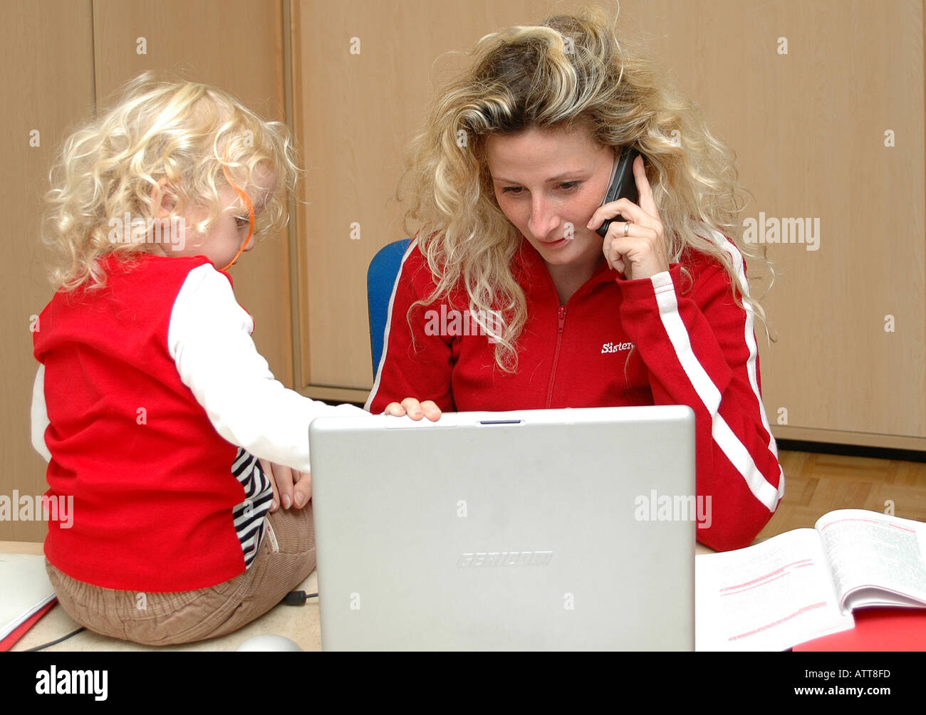 Signor Arbeitende Mutter mit tipo am Computer MR funziona madre con bambino in office online Bildagentur Begsteiger Foto Stock