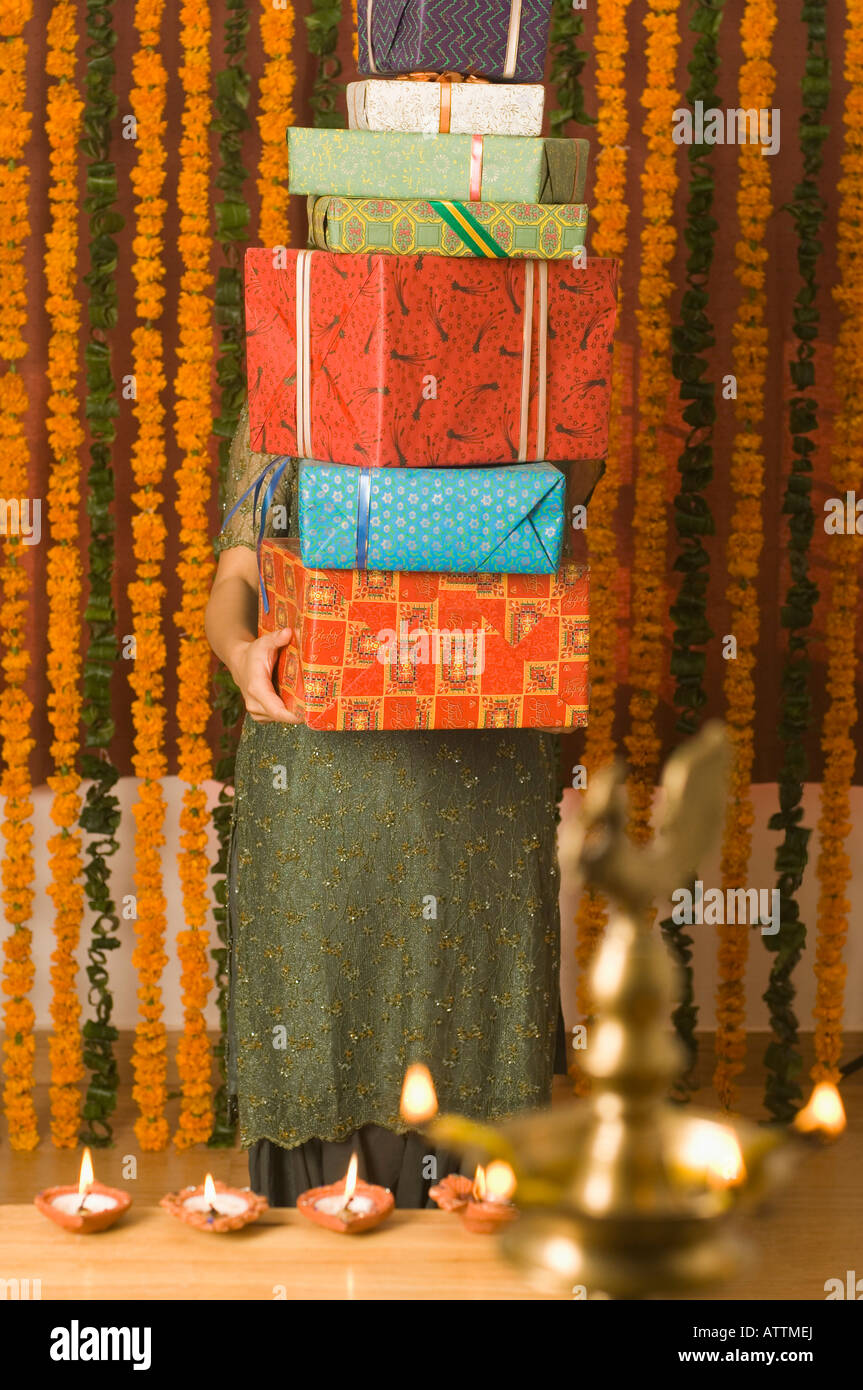 Giovane donna una catasta di diwali doni Foto Stock