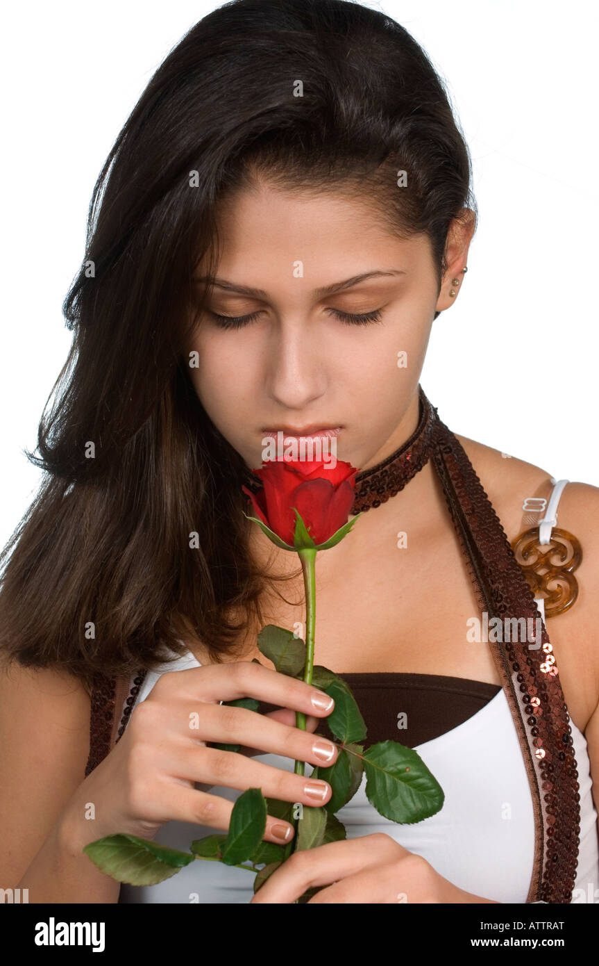 Giovane e bella ragazza adolescente odorare una rosa rossa Foto Stock