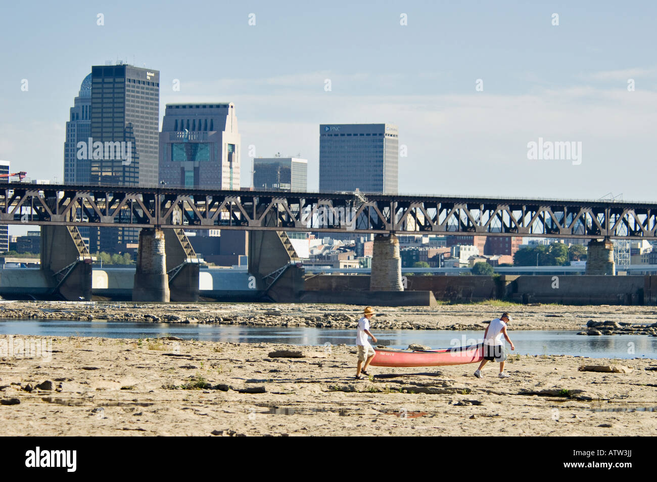 Due uomini che trasportano canoa per il fiume Ohio al di sotto della McAlpine diga a cadute di Ohio State Park Clarksville Indiana Foto Stock