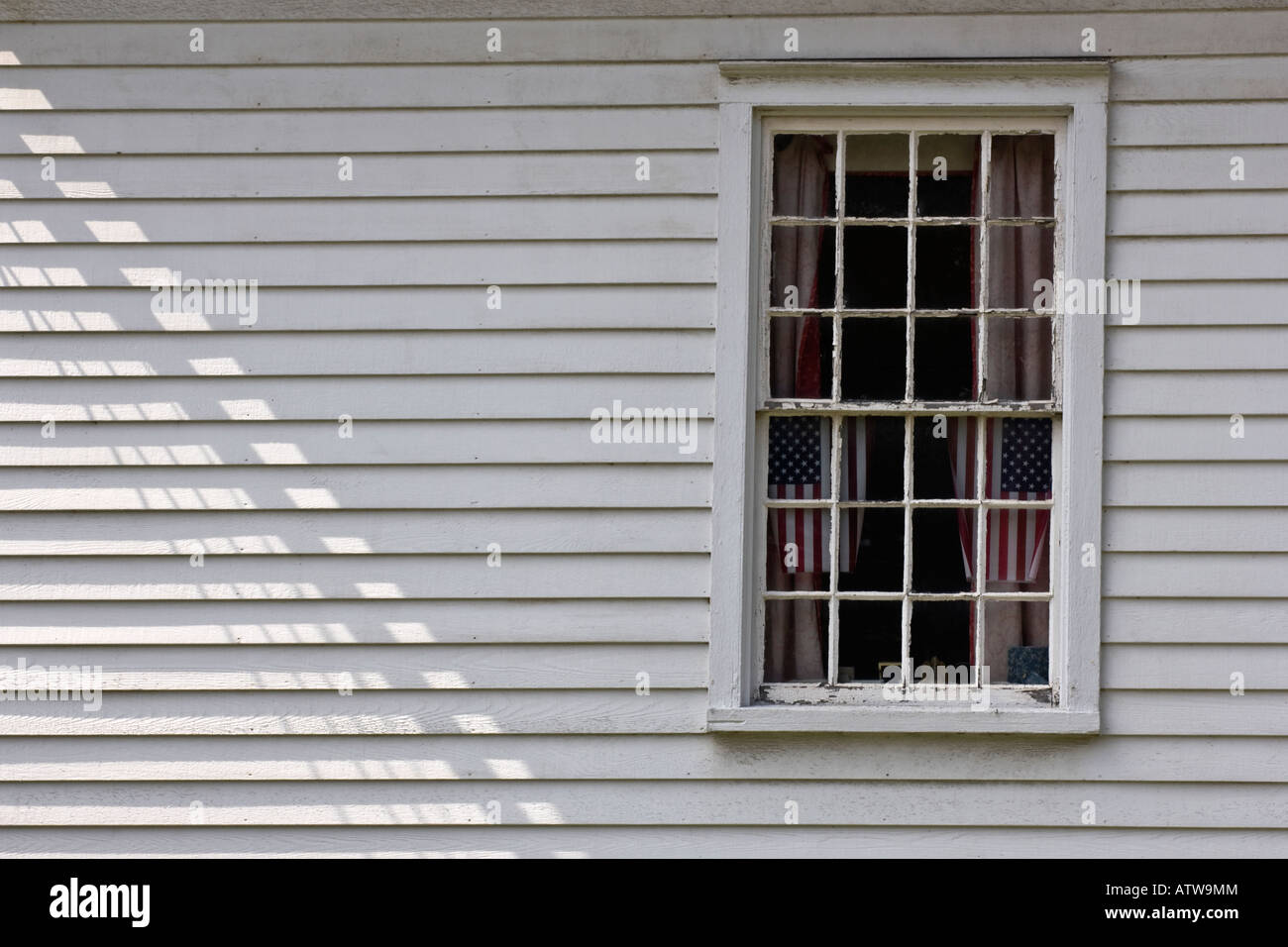 Due bandierine americane sul display nella finestra di edificio bianco con rivestimenti in legno Foto Stock