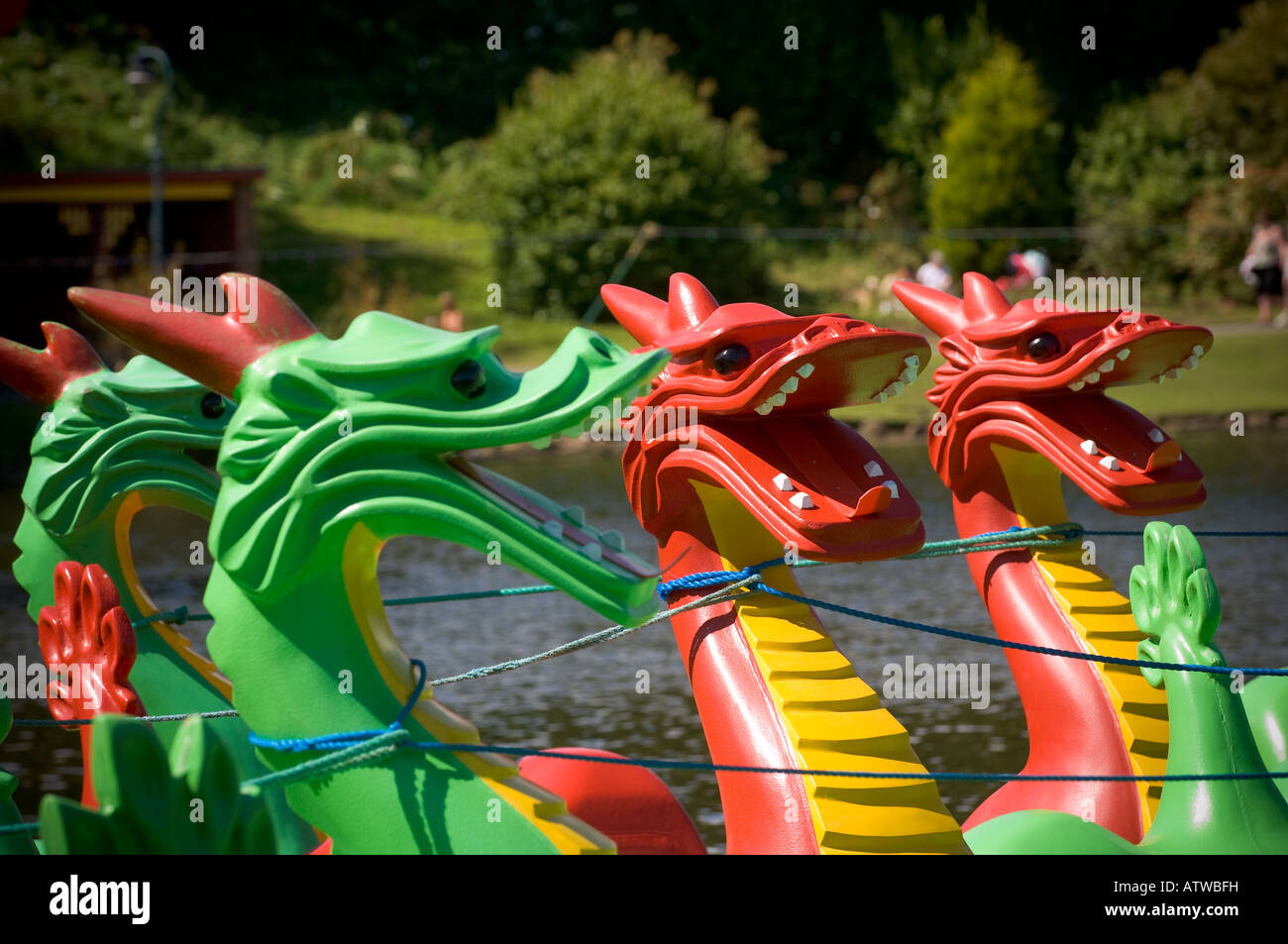 Primo piano di teste verdi e rosse di drago su pedalò ormeggiato al bordo del lago al Parco di Peasholme a Scarborough. North Yorkshire. REGNO UNITO Foto Stock