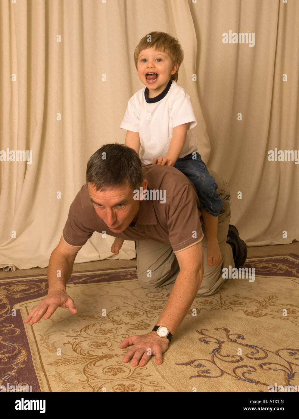 Nonno vecchio padre giocando con il nipote figlio dandogli un piggyback o cavallo Foto Stock