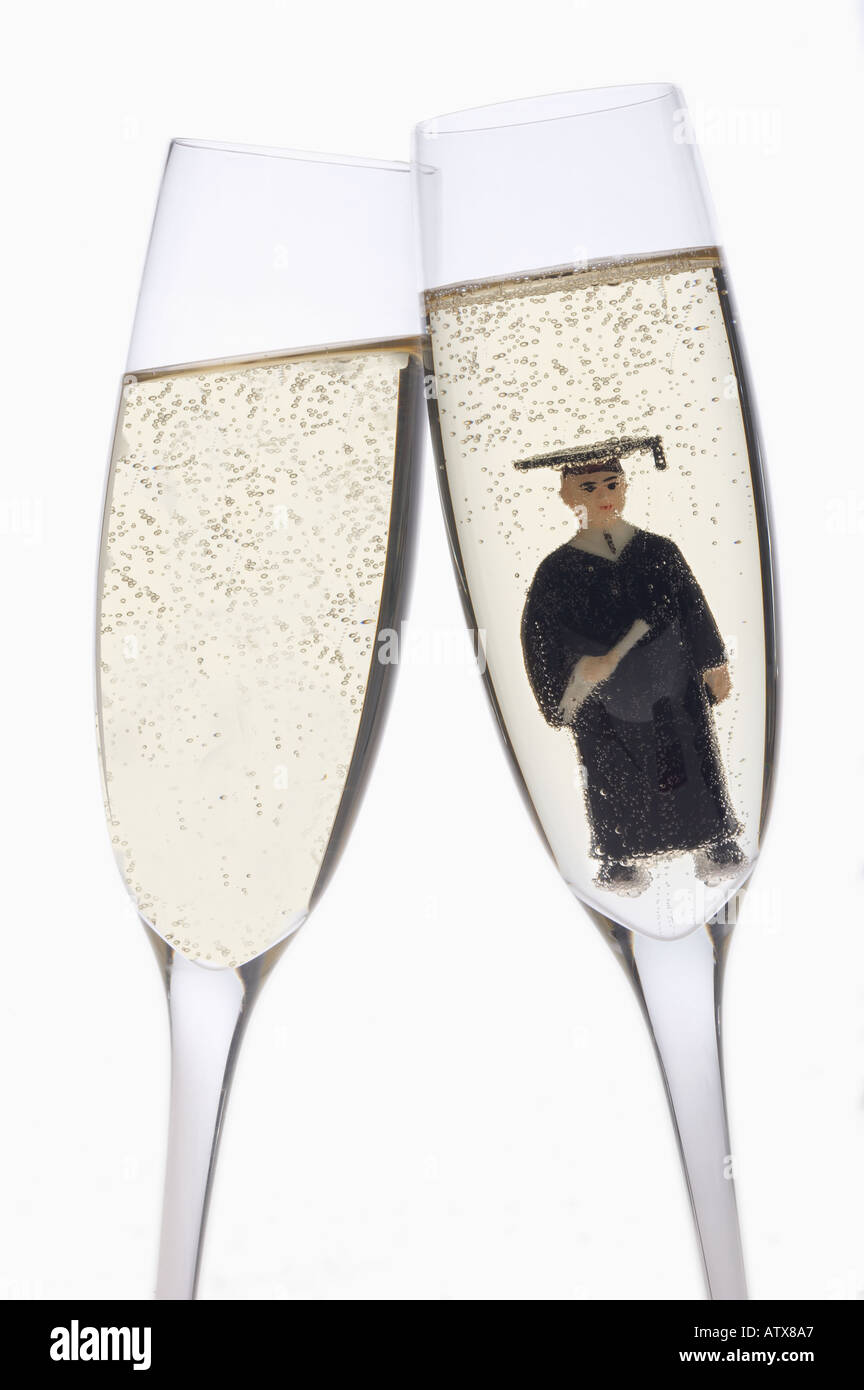 Ancora la vita di due bicchieri di champagne su uno sfondo bianco con la figurina di un laureato all'interno Foto Stock