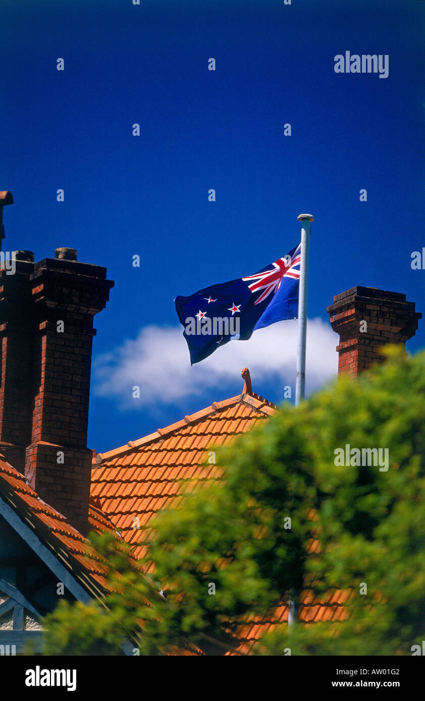 La parte superiore del tetto di Mona Vale una casa Vittoriana situato in un giardino con la Nuova Zelanda bandiera sul pennone Christchurch Foto Stock