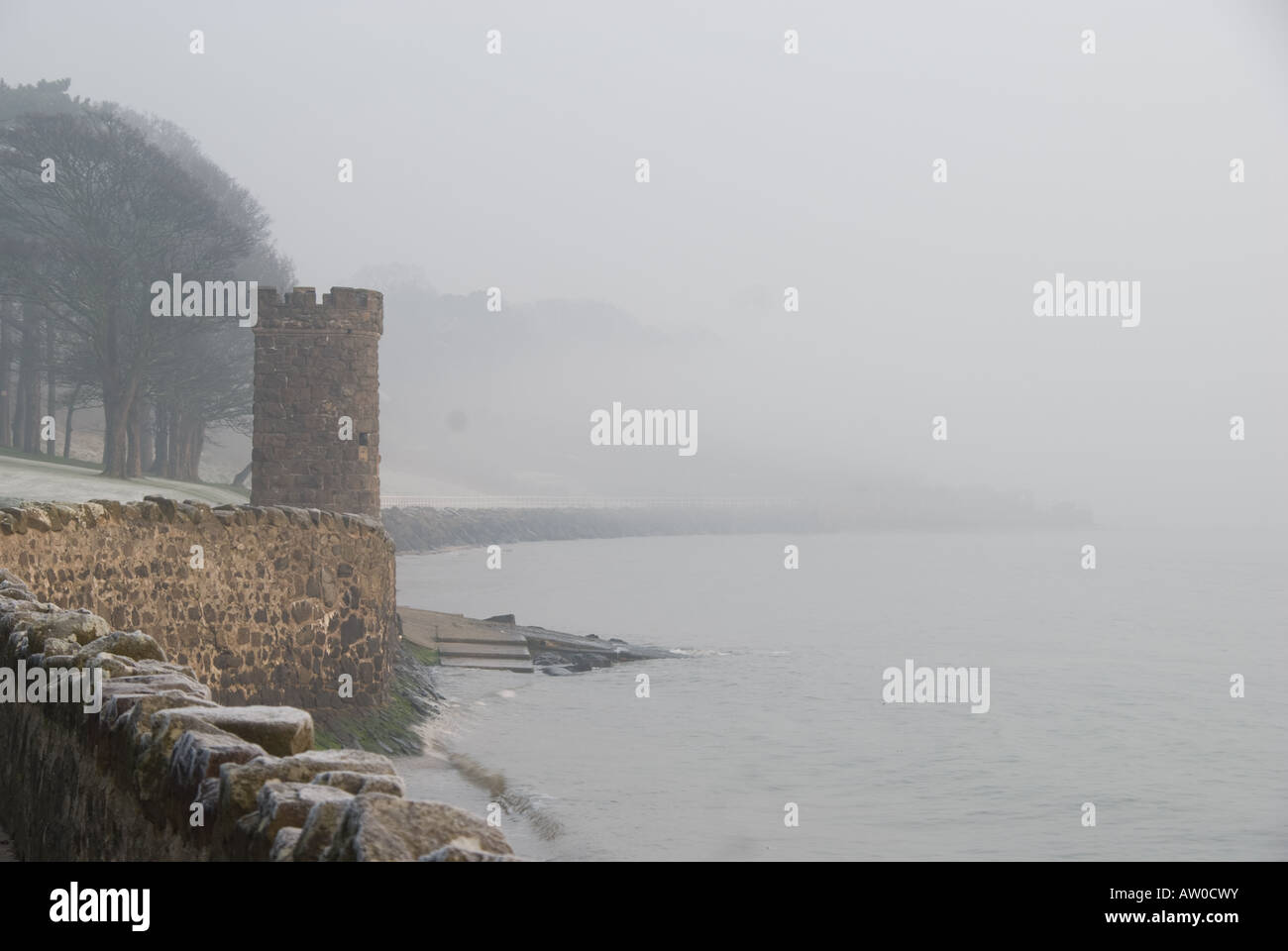 La nebbia oltre Hazelbank Park, Newtownabbey, Irlanda del Nord con torre di castello/torretta contro il mare Foto Stock