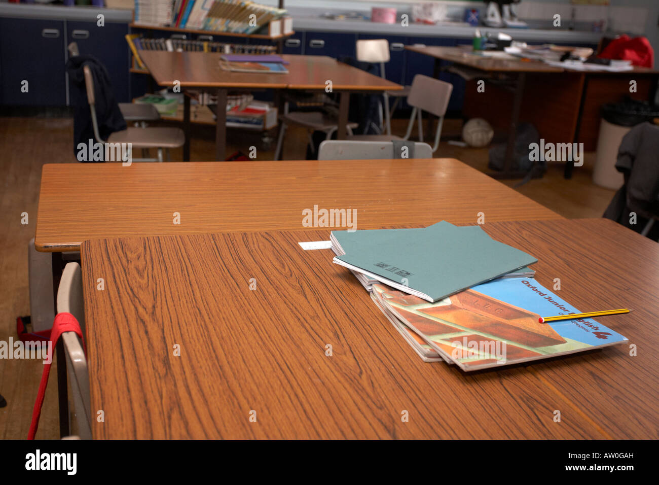 Libri scolastici e libri di testo di inglese seduti sui tavoli in un vuoto di scuola primaria aula belfast Irlanda del Nord Regno Unito Foto Stock