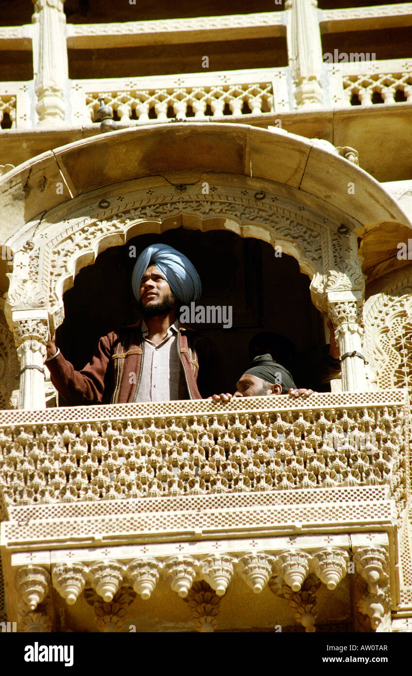 India Rajasthan Jaisalmer Fort royal palace uomini Sikh su riccamente intagliato nella finestra di pietra balcone Foto Stock