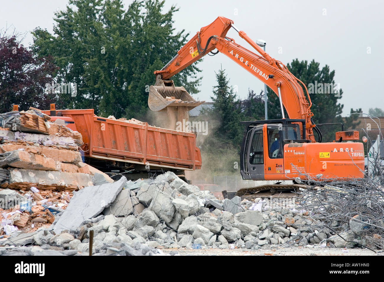 Un escavatore è carico di macerie edili Foto Stock