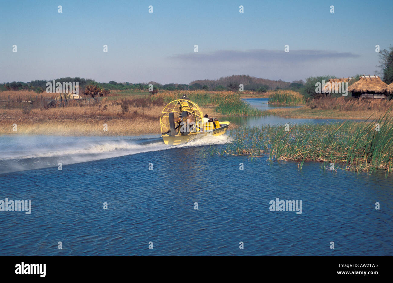 Fast yellow airboat velocità passato Indiani Seminole vecchio tetto di paglia di stile chickee abitazione Florida Everglades Foto Stock