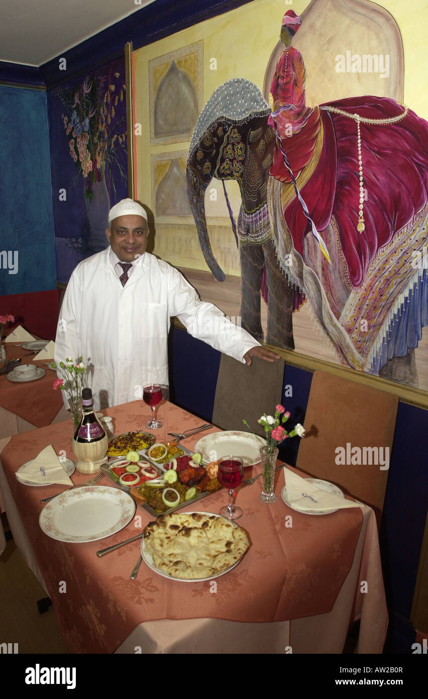 Restauranteur vi accoglie per un tavolo nella sua casa di curry Foto Stock