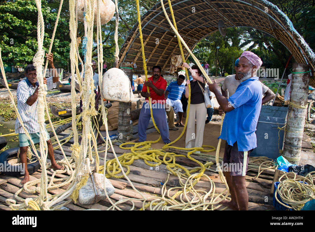 I pescatori tirando le reti da pesca cinesi funi, Fort Cochin, Cochin, Kerala, India Foto Stock