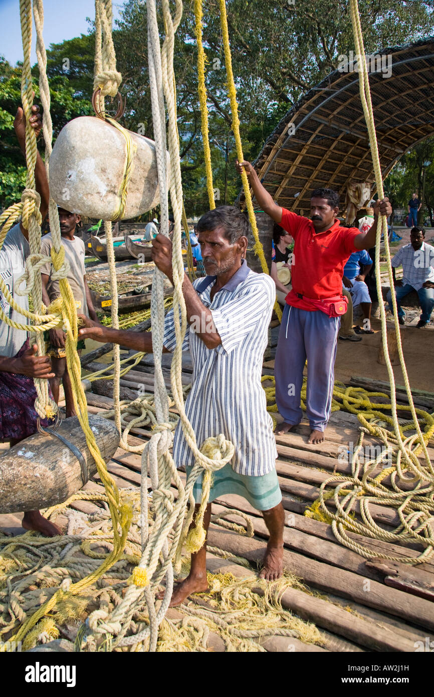 I pescatori tirando le reti da pesca cinesi funi, Fort Cochin, Cochin, Kerala, India Foto Stock