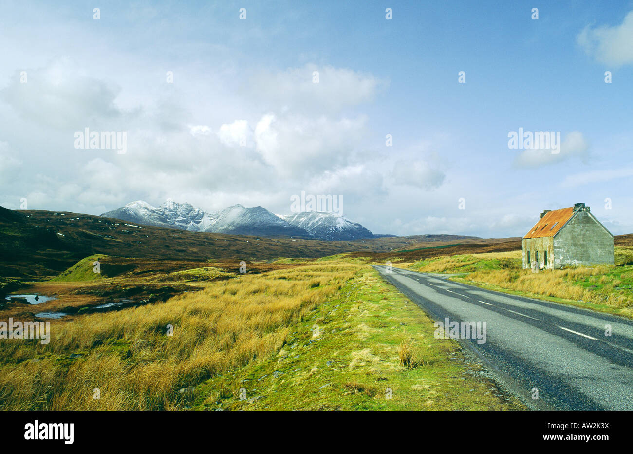 A sud di Ullapool in Wester Ross, Scotland, Regno Unito. L'alta strada attraversa la foresta Dundonnell verso l'inverno pendici di un Teallach Foto Stock