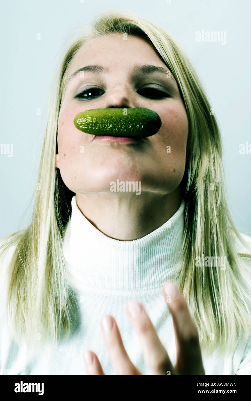 Giovane donna bionda 20-30 mangiando un cetriolo pickels Junge Frau Isst eine Essiggurke Foto Stock