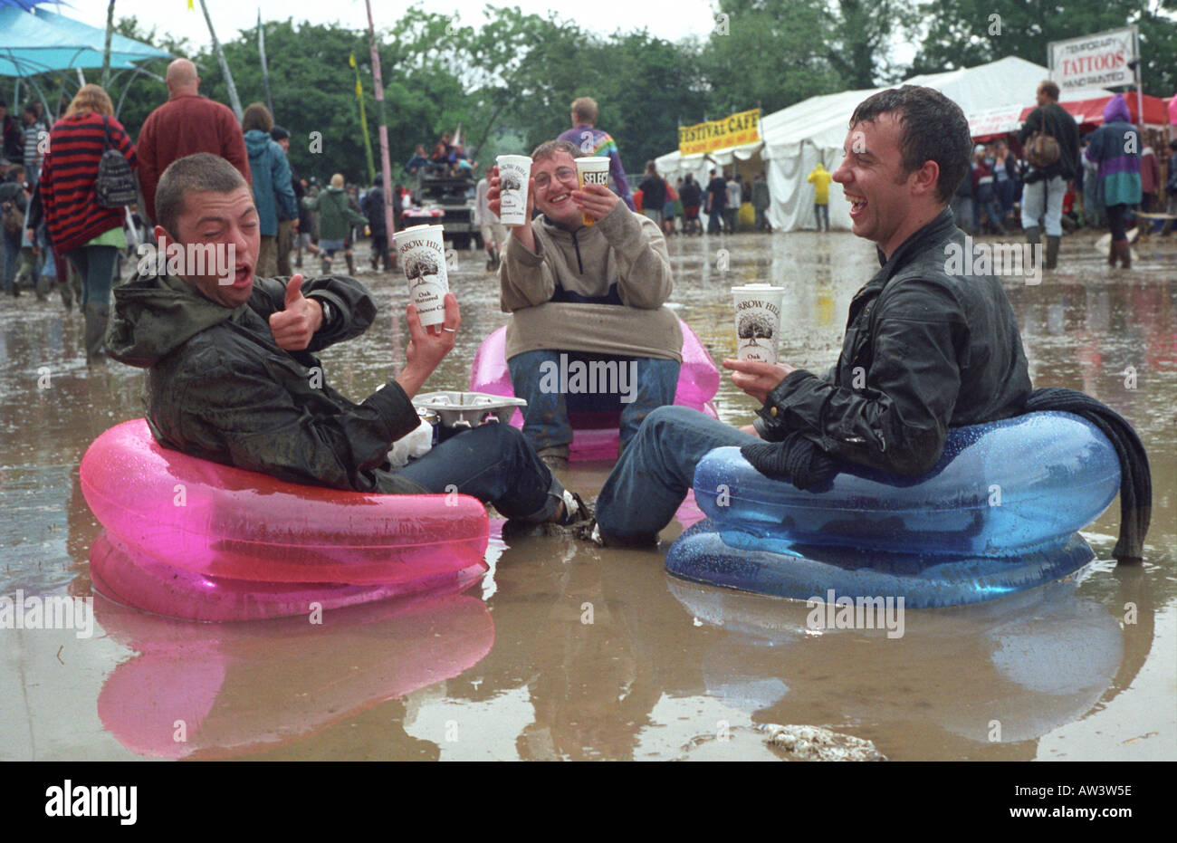 Glastonbury 1998 tre festaioli godetevi il sidro di mele da sidro bus, nonostante le intemperie Foto Stock