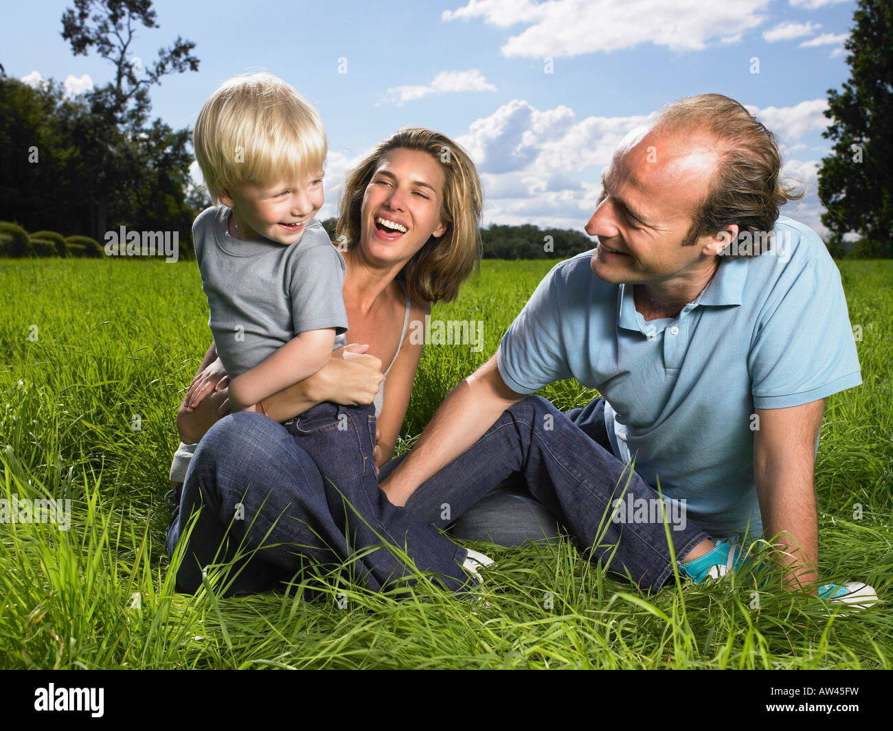 La famiglia che gode di una buona volta in un campo. Foto Stock