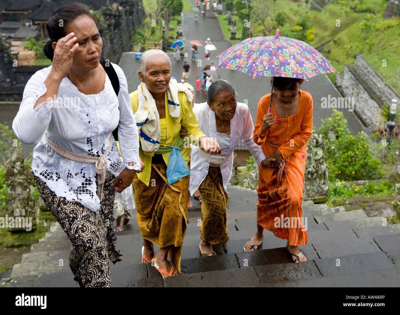 Una processione funebre che porta ombrelli salendo la scalinata fino alla pura Tempio Besakih Bali Indonesia Foto Stock