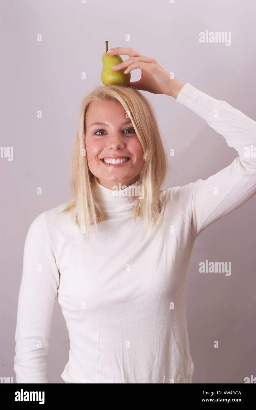 Donna bionda con pera | Blonde Junge Frau 20-30 mit einer Birne auf dem Kopf Foto Stock