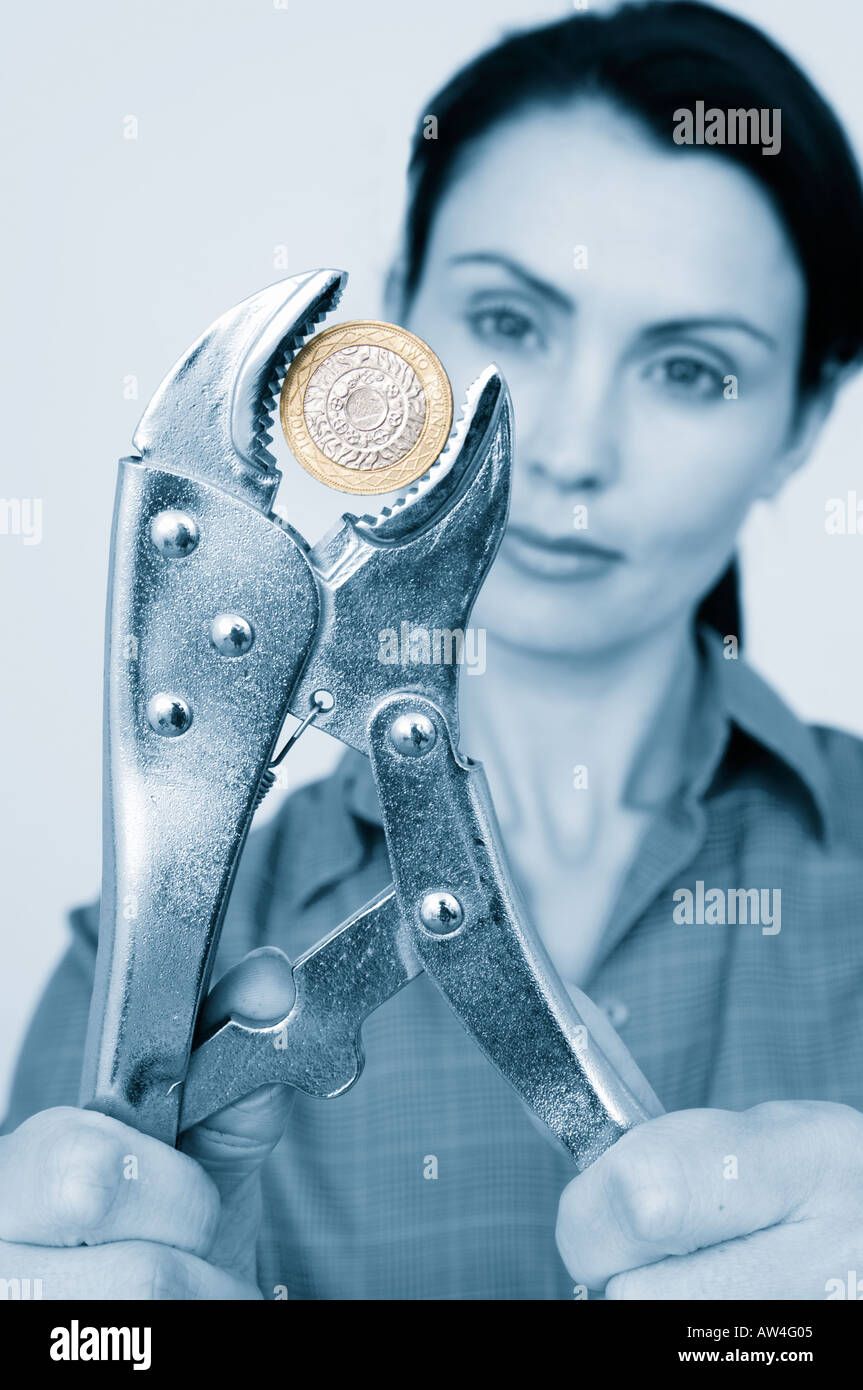 Esercitare pressione sul pound pressione finanziaria donna con una chiave la spremitura di una due pound coin Foto Stock