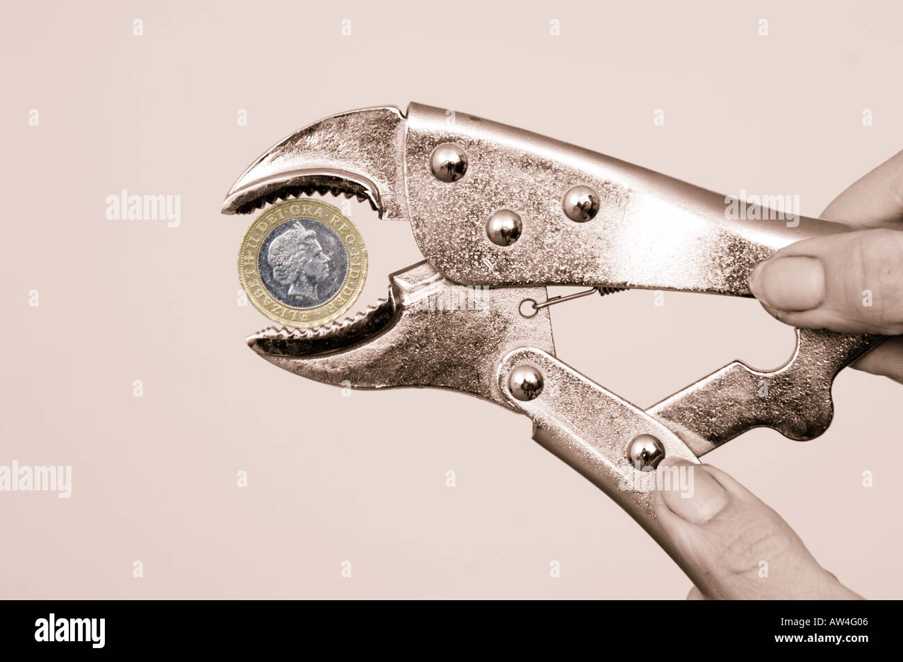 Esercitare pressione sul pound mani con la chiave la spremitura di una due pound coin Foto Stock
