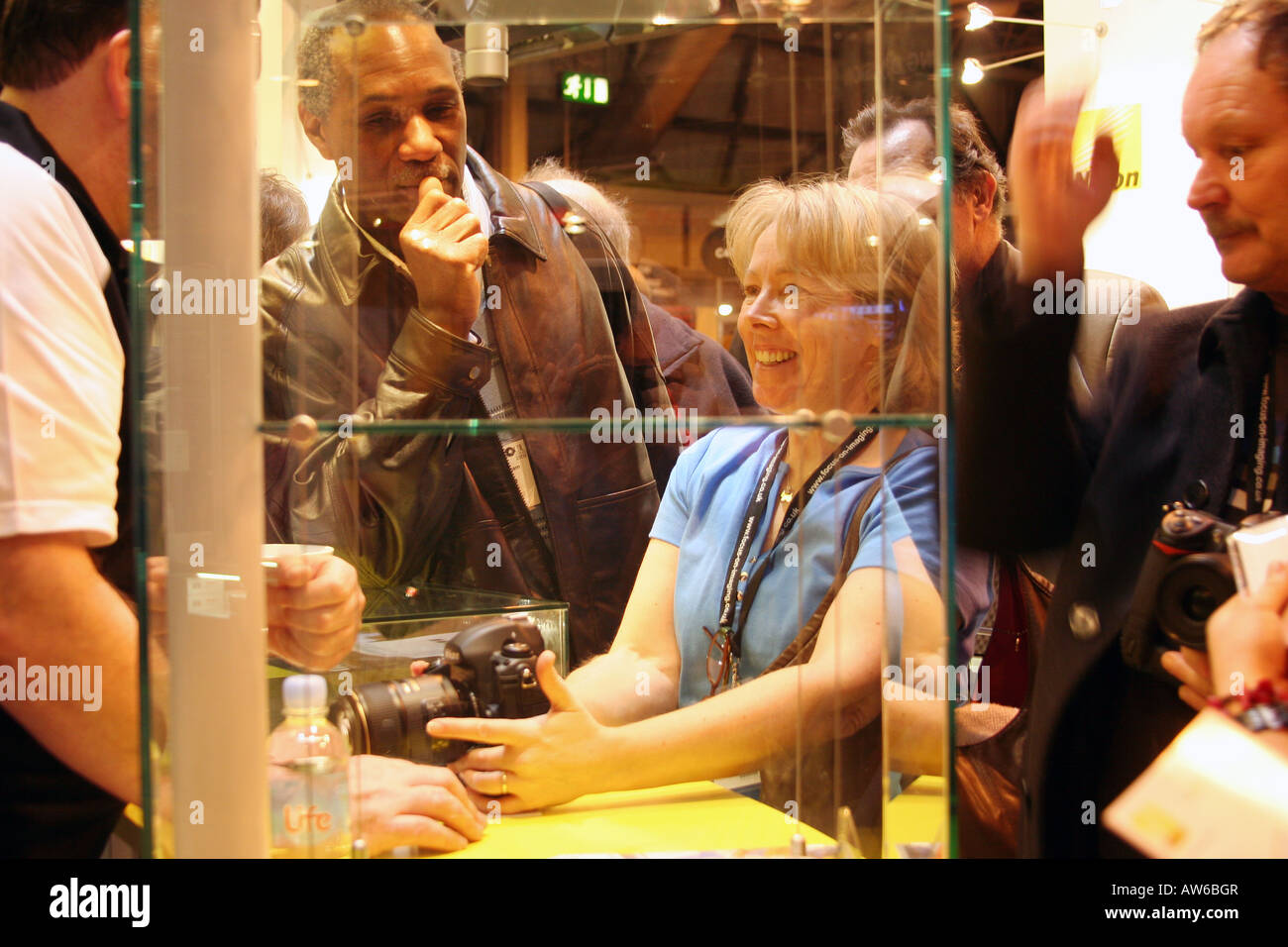 Gruppo di persone che guardano attrezzature fotografiche in occasione di una mostra. Foto Stock