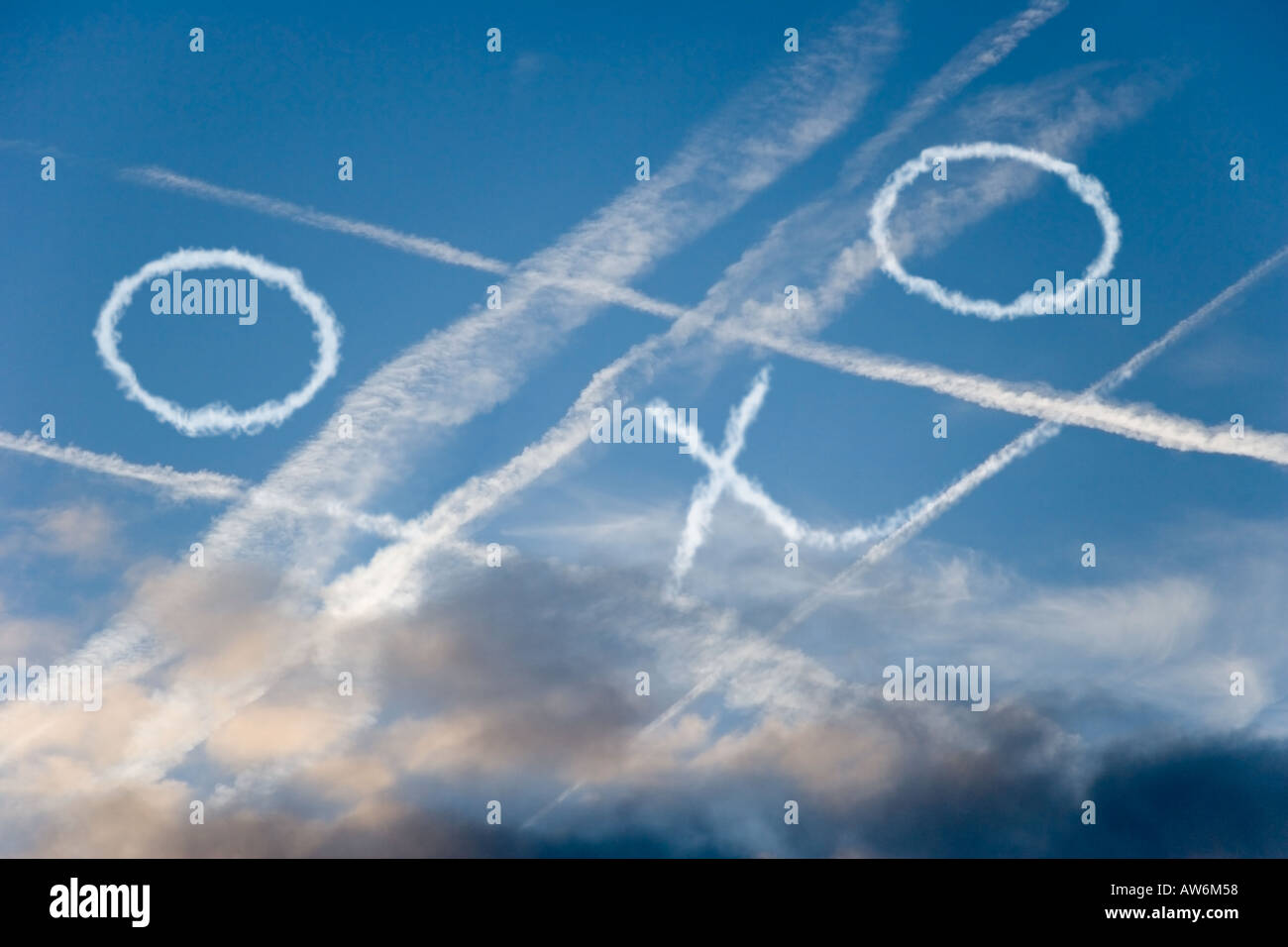 Attraversato CONTRAILS nel cielo blu con una partita di tris Foto Stock