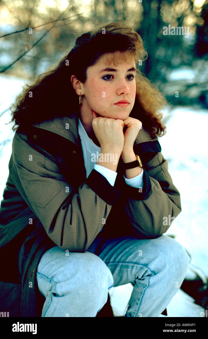17 anno vecchia ragazza pensieroso seduto su una roccia nella neve. Mound Minnesota USA Foto Stock