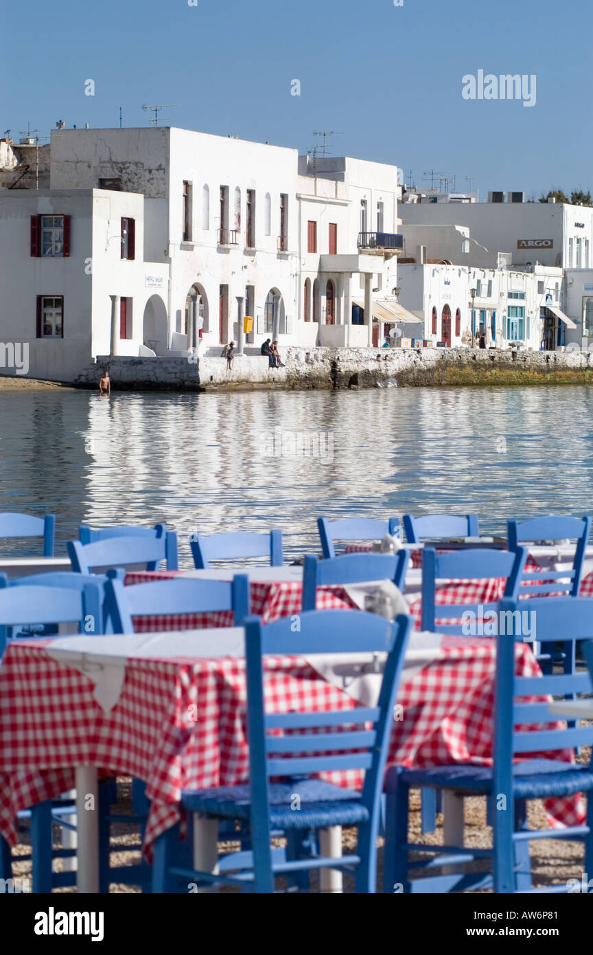 Sedie blu e tovaglie a scacchi in un ristorante sul mare a Mykonos, Grecia. Foto Stock