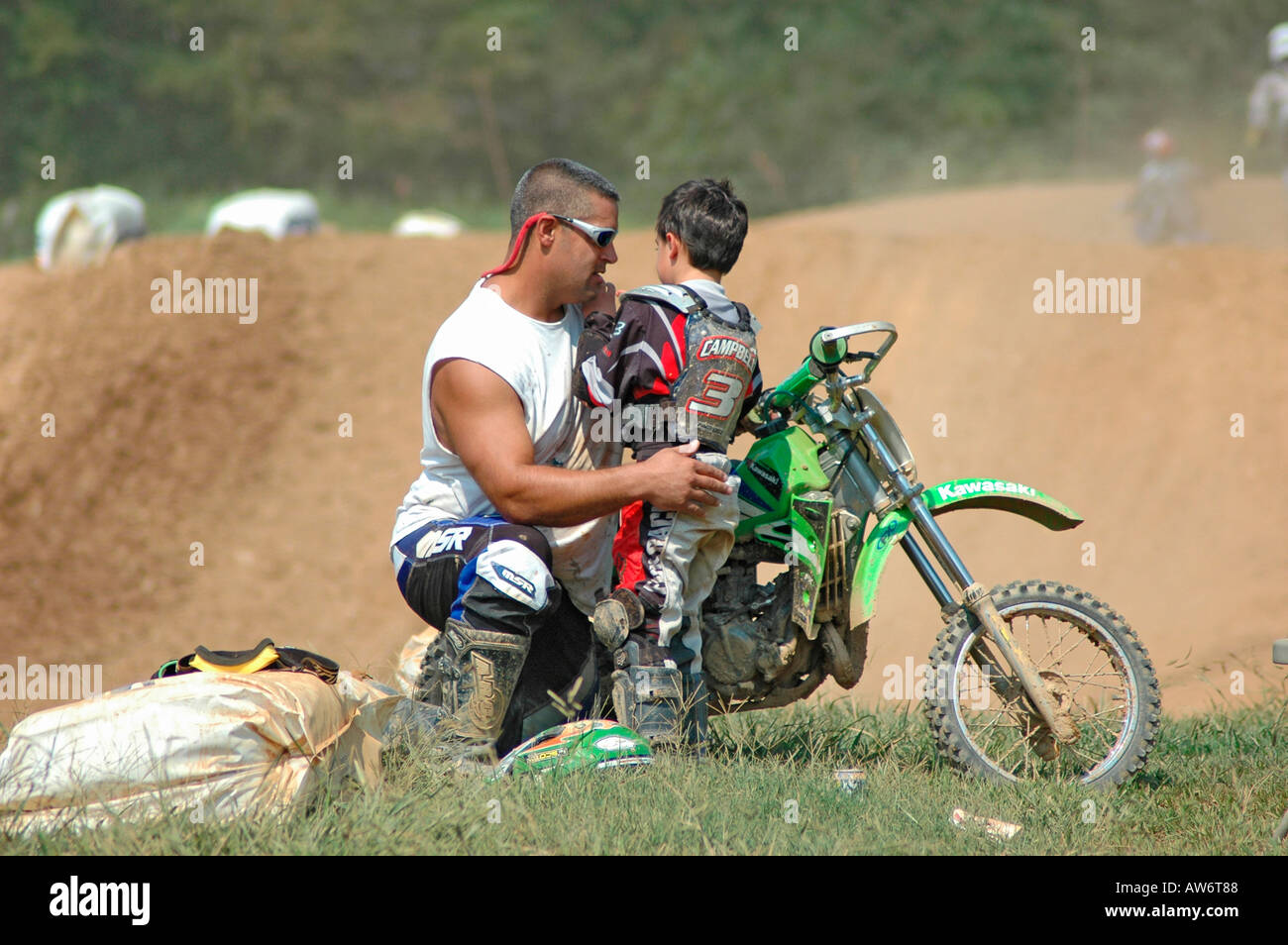 Padre e figlio di parlare, di essere rassicurati dal papà, dopo il crash sul ciclo di MX dirk race track durante la pratica e l'apprendimento. Foto Stock