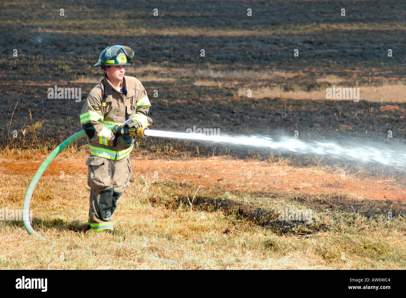 Vigili del fuoco che combattono un incendio a pennello nella zona di Atlanta con acqua e attrezzature di sicurezza Foto Stock