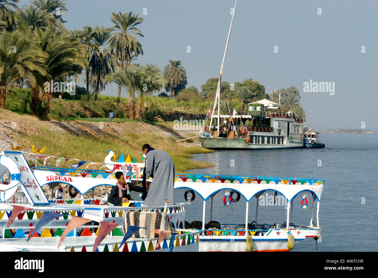 Ferry man assiste il suo taxi d'acqua sul Nilo a Luxors West Bank, Luxor, Egitto . Lo sfondo è la Dahabiyya chiamato Hadeel Foto Stock