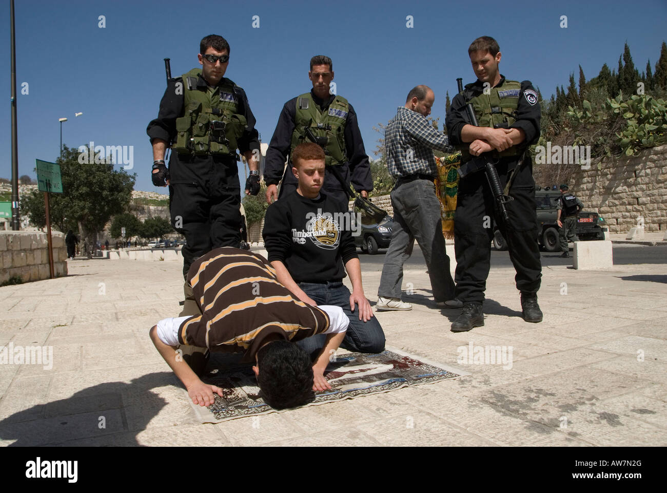 I membri delle forze di sicurezza israeliane stanno in guardia mentre i palestinesi pregano a Gerusalemme est Israele Foto Stock