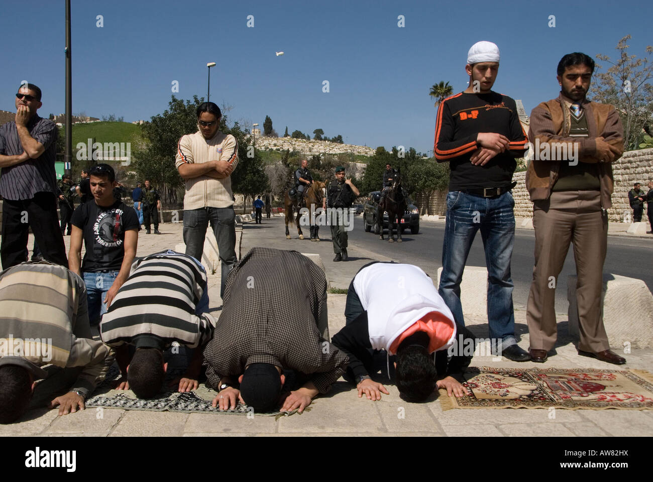 Palestinesi pregare come israeliani gli ufficiali di polizia guardia a Gerusalemme Est Israele Foto Stock