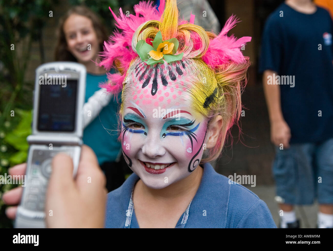 La ragazza di trucco teatrale che è fotografata con Motorola Razr telefono cellulare Foto Stock