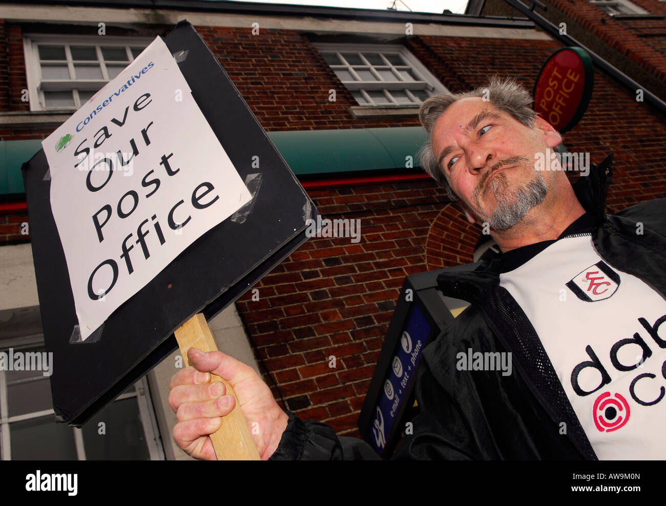 61 anno vecchio protestando per eventuale chiusura del suo ufficio postale locale High Street New Malden Surrey Foto Stock