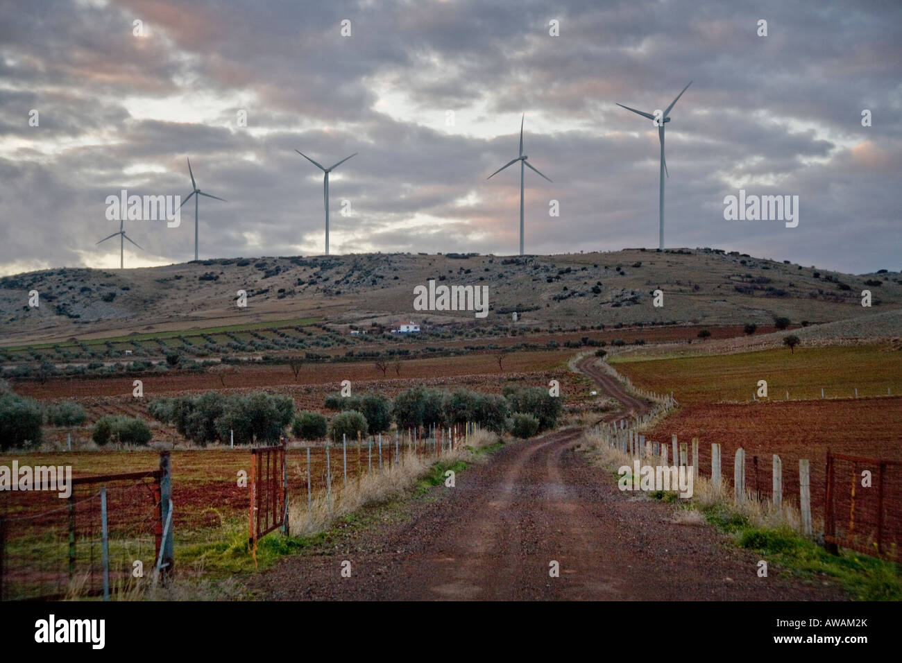 Centrali eoliche generatori elettrici in contrasto con un'antica strada di campagna nel centro della Spagna Foto Stock